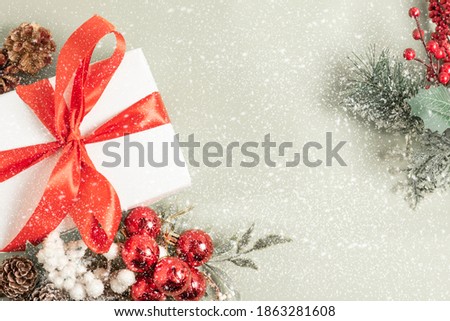 Christmas composition. Gift, for tree branches,  balls decorations on snowflakes background.