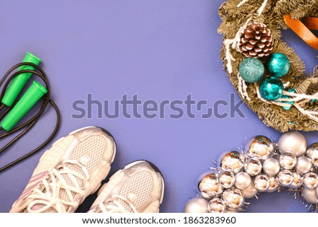 Sport equipment (rope, sneakers) with new year decorations on blue background. Flat lay, top view with copy space.  Fitness, sport and healthy lifes.