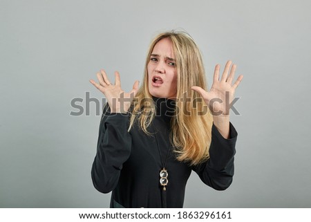 Afraid holding palms to camera as stay there sign, in panic, facial pain, struggles with outstretched hands up, scared domestic abuse, mouth wide open. Young attractive woman, dressed black sweater