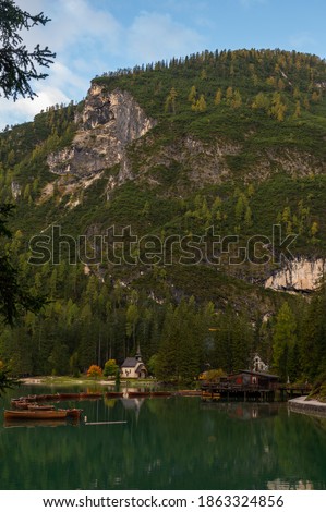 Little chapel and boatshouse at Lake Braies (Pragser Wildsee, Lago di Braies) with boats in foreground. Region of Trentino Alto Adige, Dolomites, Italy Royalty-Free Stock Photo #1863324856