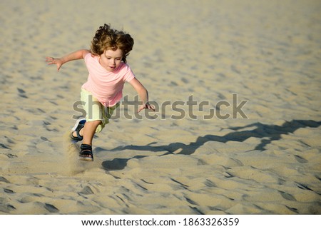 Child play with sand on beach. Active kid having fun on summer vacation