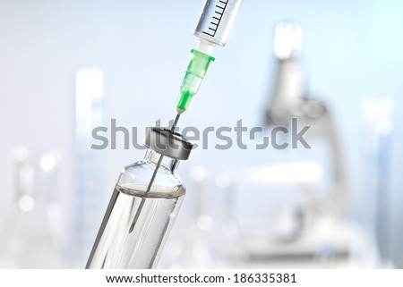 Syringe and vaccine front of a laboratory scene Royalty-Free Stock Photo #186335381