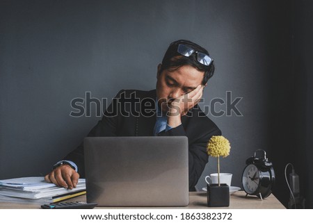 Asian businessman falling asleep at office desk with closed eyes, overworked young man, unmotivated worker sleeping at workplace, boring of routine work Royalty-Free Stock Photo #1863382372