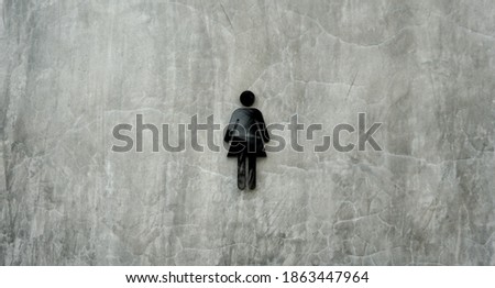 A women toilet sign on monochromic concrete background.