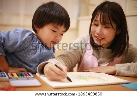 Image of a boy and a nursery teacher drawing
