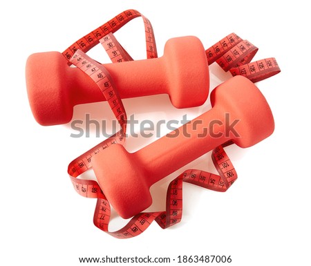 two pink drumbells and measurig tape isolated on white background