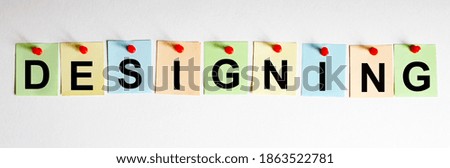 DESIGNING phrase is written on multi-colored stickers, on the white background. Business concept, strategy, plan, planning.