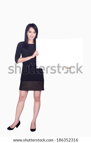 Attractive business woman hold empty blank board, full length portrait isolated on white background. 