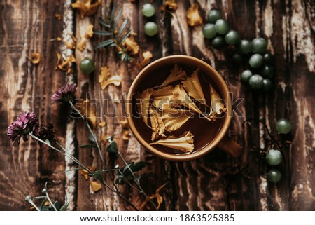 herbal tea. herbal tea in an orange mug on a wooden table. berries, herbs, flowers and tea on a brown wooden table. summer still life with herbs on the kitchen table Royalty-Free Stock Photo #1863525385