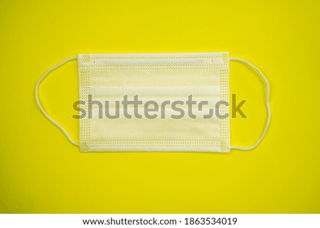 Antibacterial medical mask for children of white color on a yellow background. Coronavirus Protection concept. Hight quality photo