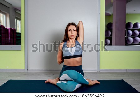 
Attractive girl practices yoga in the fitness room. Healthy lifestyle concept.