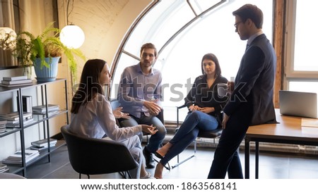 Young multiracial colleagues friends chatting talking discussing work company policy on informal meeting, diverse millennial managers mates have conversation sharing news ideas at break time in office Royalty-Free Stock Photo #1863568141