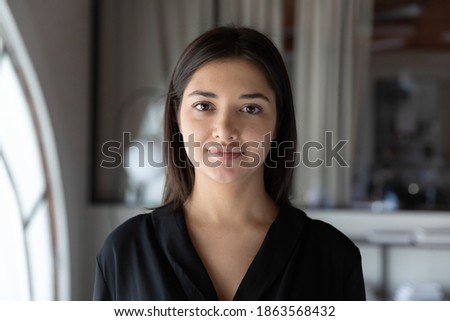 Profile picture of calm smiling indian female customer service worker assisting client online, portrait of confident mixed race woman coach tutor looking at camera providing webinar business training