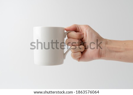 hand holding cup on white background Royalty-Free Stock Photo #1863576064