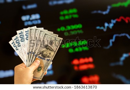 American dollar and Turkish lira on woman's hand and stock market screen, money chart background Royalty-Free Stock Photo #1863613870