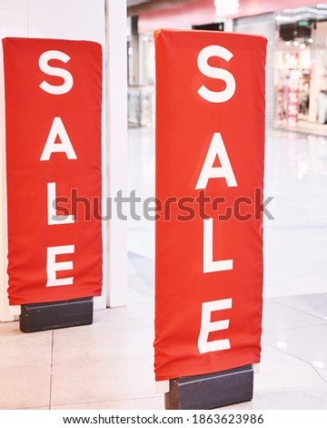 Sale. Red sign at mall. Discount concept. Market interior design. Selling business model. Lifestyle promotion. Store promo graphic. Shop background. Boutique. Retail commercial price. Money offer