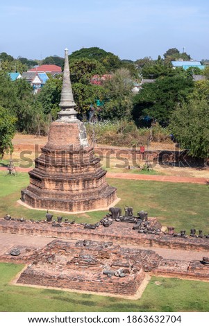 Aerial picture of stupa made of bricks, broken statues of Buddha surrounding the pagoda. Ruins of Buddhist temple Wat Ratchaburana, Ayutthaya historical park, Thailand, Southeast Asia. 