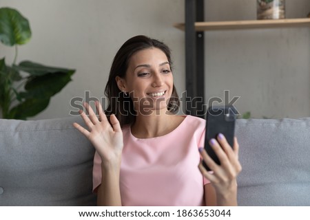 Happy attractive millennial arab indian woman holding video web camera call on smartphone, talking speaking chatting with friends or parents at home, distant communication modern tech concept. Royalty-Free Stock Photo #1863653044