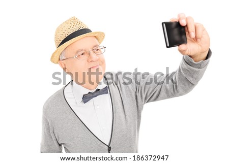 Senior gentleman taking a selfie with cell phone isolated on white background