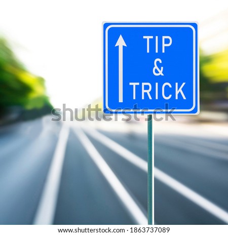 Tip and trick motivational phrase on blue road sign with arrow and blurred speedy background copy space