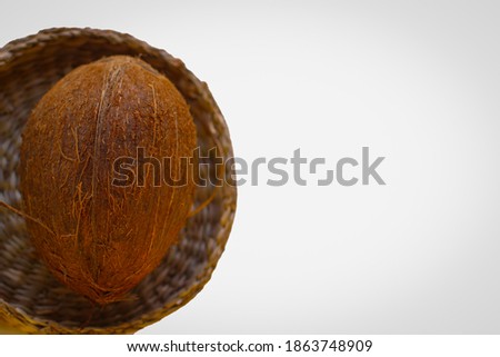 One Coconut In A Wicker Plate In Selective Focus. Isolated Image On A White Background With Copy Space.