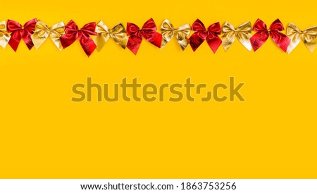 horizontal Christmas yellow background: red and gold bows in a row along the top edge