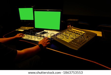  sound engineer working in digital audio and video editing post production studio.Green screen.Selective focus.                               