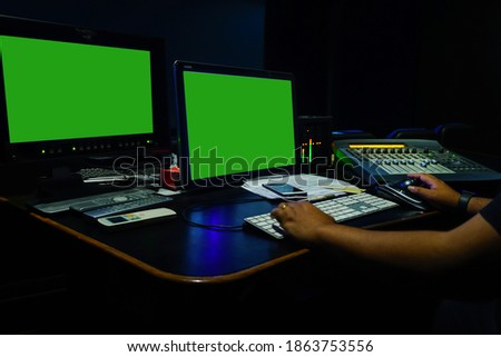 sound engineer working in digital audio and video editing post production studio.Green screen.Selective focus.                               