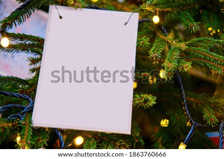 Old postcard on a Christmas tree, mockup. Garland lights and decoration for the new year, copy space
