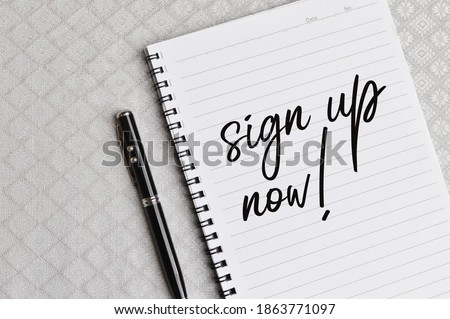 Top view of pen and notebook written with text SIGN UP NOW!. Business and education concept. 
