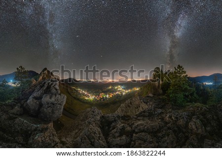 A picturesque village between rocky mountains under the night sky and the Milky Way, 360 degrees panorama