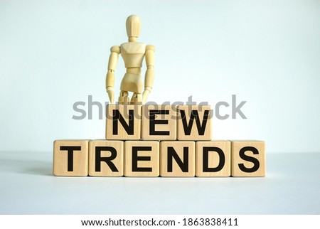 New trends. Concept words 'new normal' on cubes on a beautiful white table. Wooden model of human. Beautiful white background. Business and new trends concept.