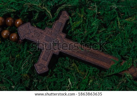 the wooden cross lies in the moss