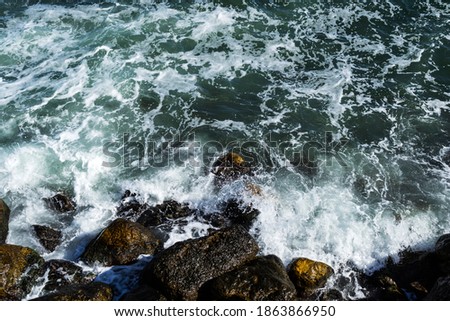 Sea waves crashing on rocks coast and the sea foam. Black sea, Constanta, Romania.