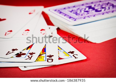 Dealt playing cards on red background.