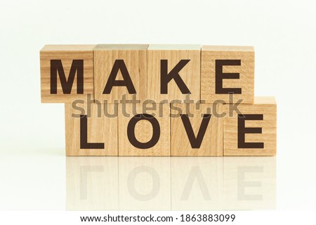 Make Love - text on wooden cubes on a gradient background. Are we gonna fly or make love