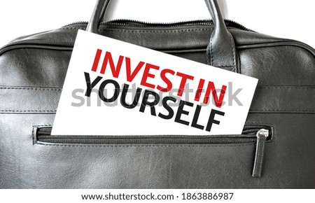 Text Invest in Yourself writing on white paper sheet in the black business bag. Business concept