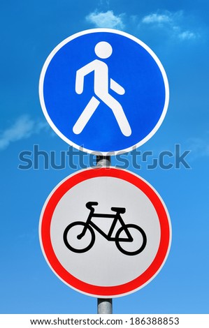 Road sign permission for pedestrians and bicycle ban on blue sky background
