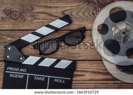 Movie clapper board and film reel, 3d glasses on wooden background. Cinema industry, entertainment. Top view