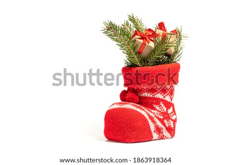 Little gifts with fir branches in Santa's boot