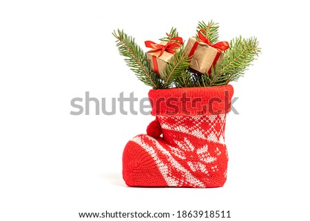 Little gifts with fir branches in Santa's boot. isolated on white