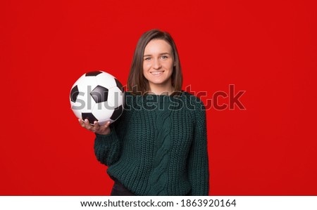 Young beautiful woman holding soccer ball over isolated background with toothy smiling and looking at camera