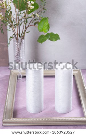 On the table are silver candles and a flower