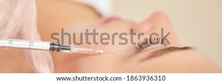 Near eye injection at spa salon. Doctor hands. Closeup. High quality. Pretty female patient. Beauty treatment. Healthy skin procedure. Young woman face. Crows feet wrinkle. Plasmolifting rejuvenation Royalty-Free Stock Photo #1863936310