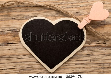 Pinned to the board with heart-shaped pegs on a wooden background.
