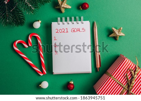 Goals, plans ,dreams, make to do list for new year 2021. Christmas concept writing in notebook on green background.