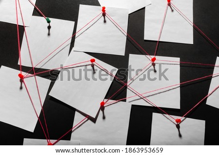 Photo of a black detecftive board with blank paper linked by red thread. Royalty-Free Stock Photo #1863953659