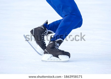 Legs of a man skating on an ice rink. Hobbies and sports. Vacations and winter activities