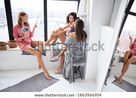 Better together. Joyful girls looking at each other while having great time at the morning at the bathroom. Stock photo