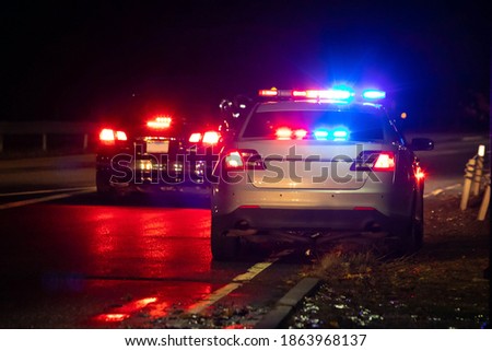 Police emergency flash lights at night from the back on highway road Royalty-Free Stock Photo #1863968137